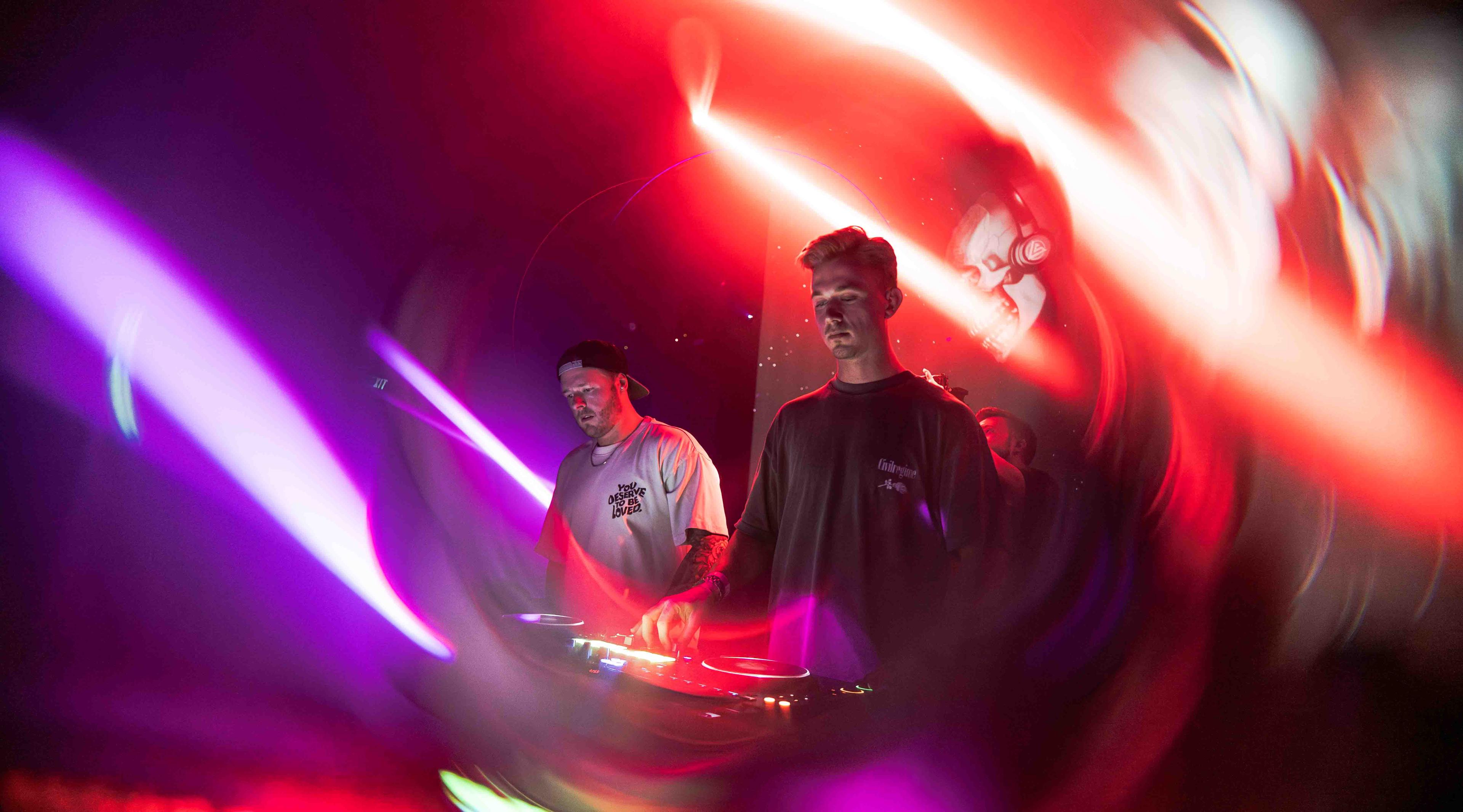 Performer bathed in amber and purple stage lights with smoke machine haze