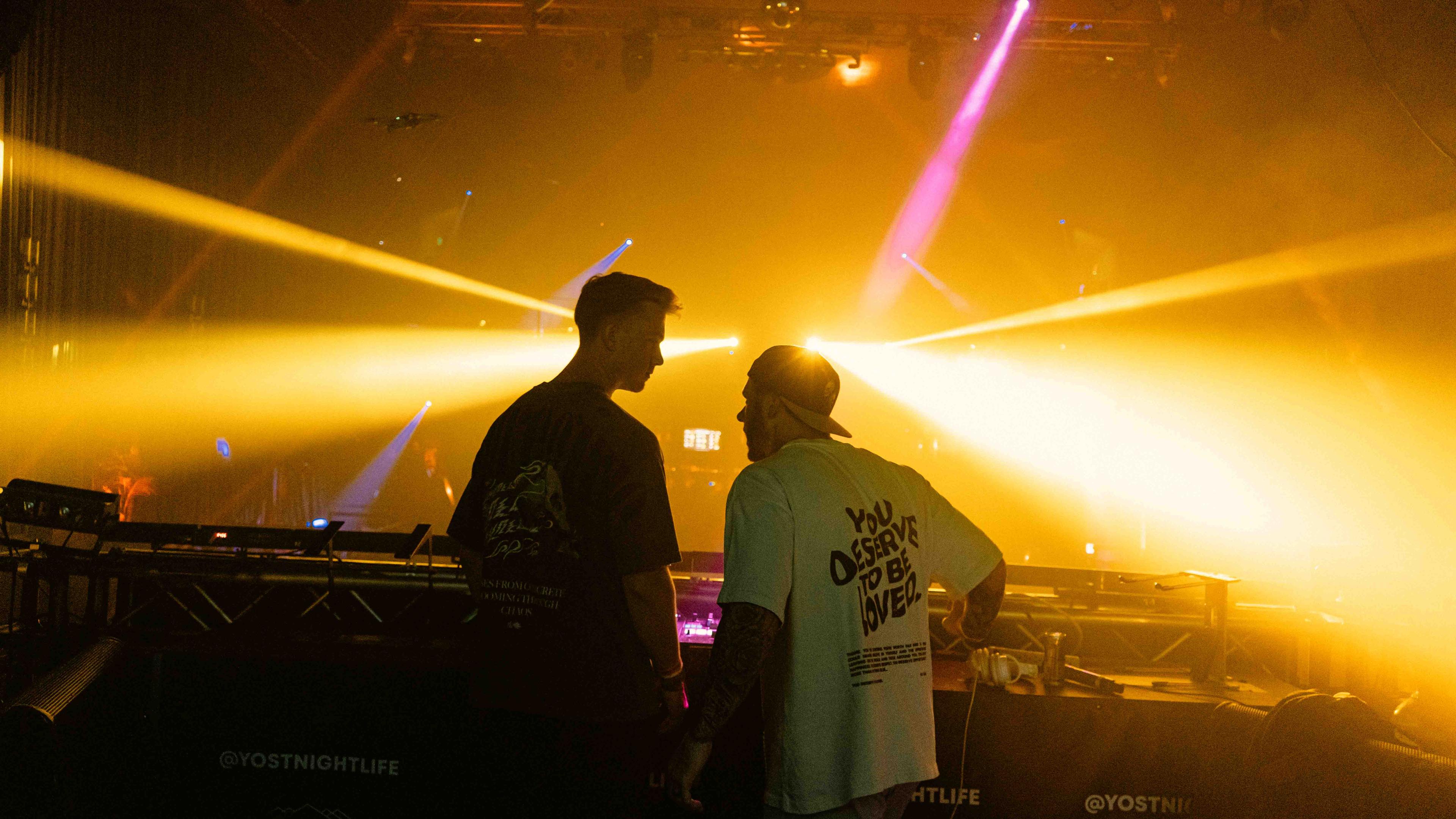Bassist performing in moody blue light with fog machine creating atmospheric haze