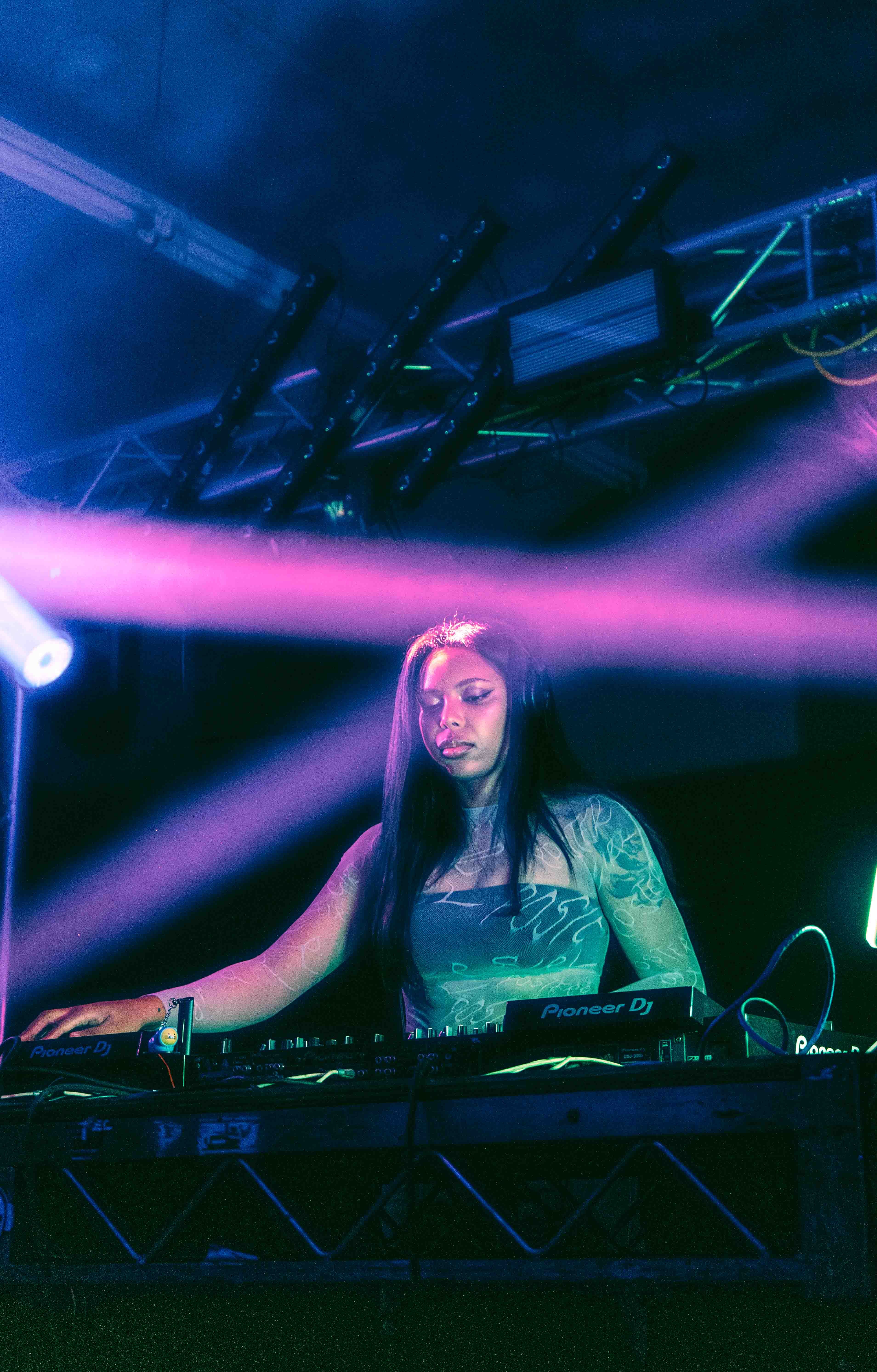 Guitarist shredding solo with dramatic lens flare from stage lighting rig