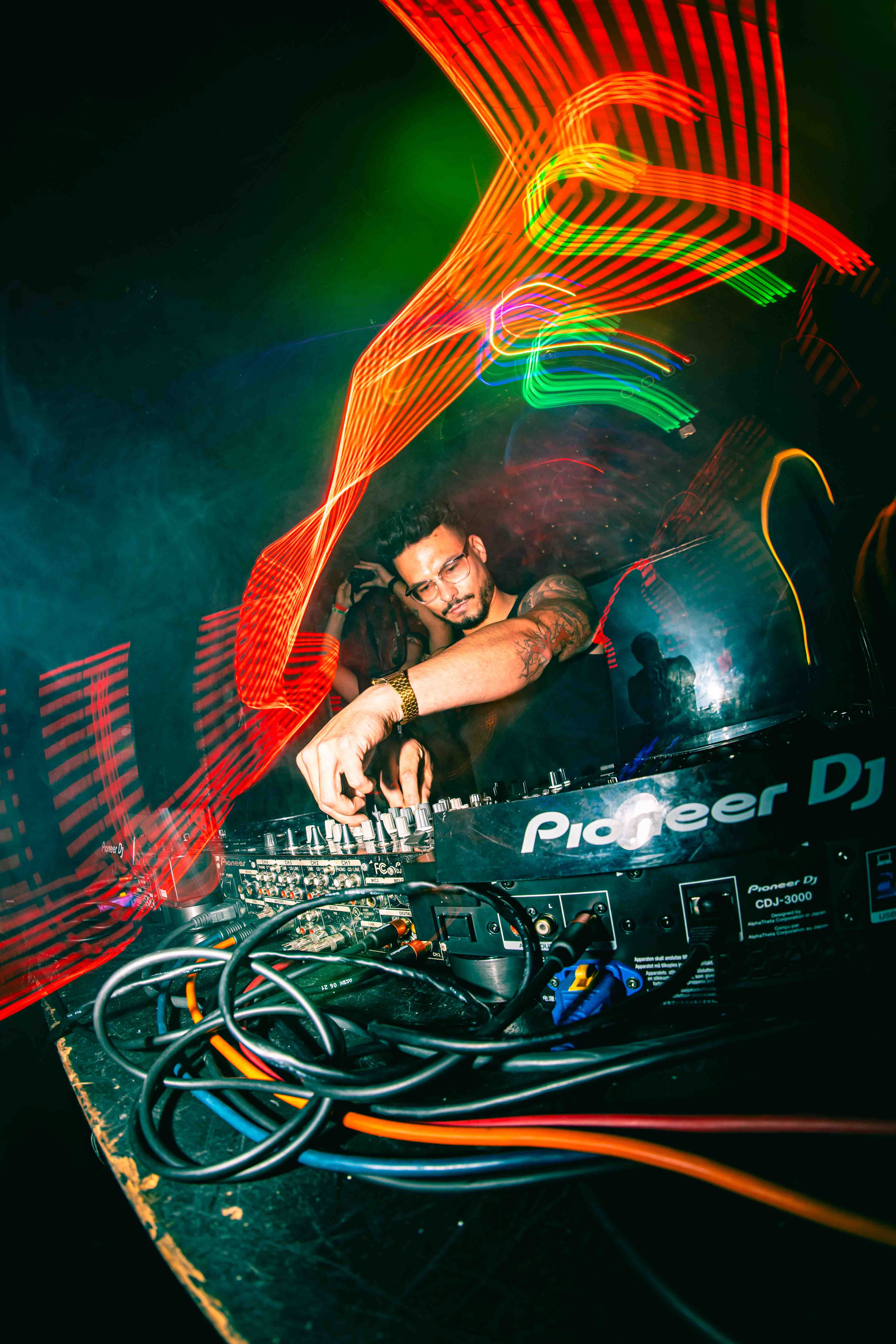 Massive outdoor festival crowd stretching to the horizon under blazing stage lights