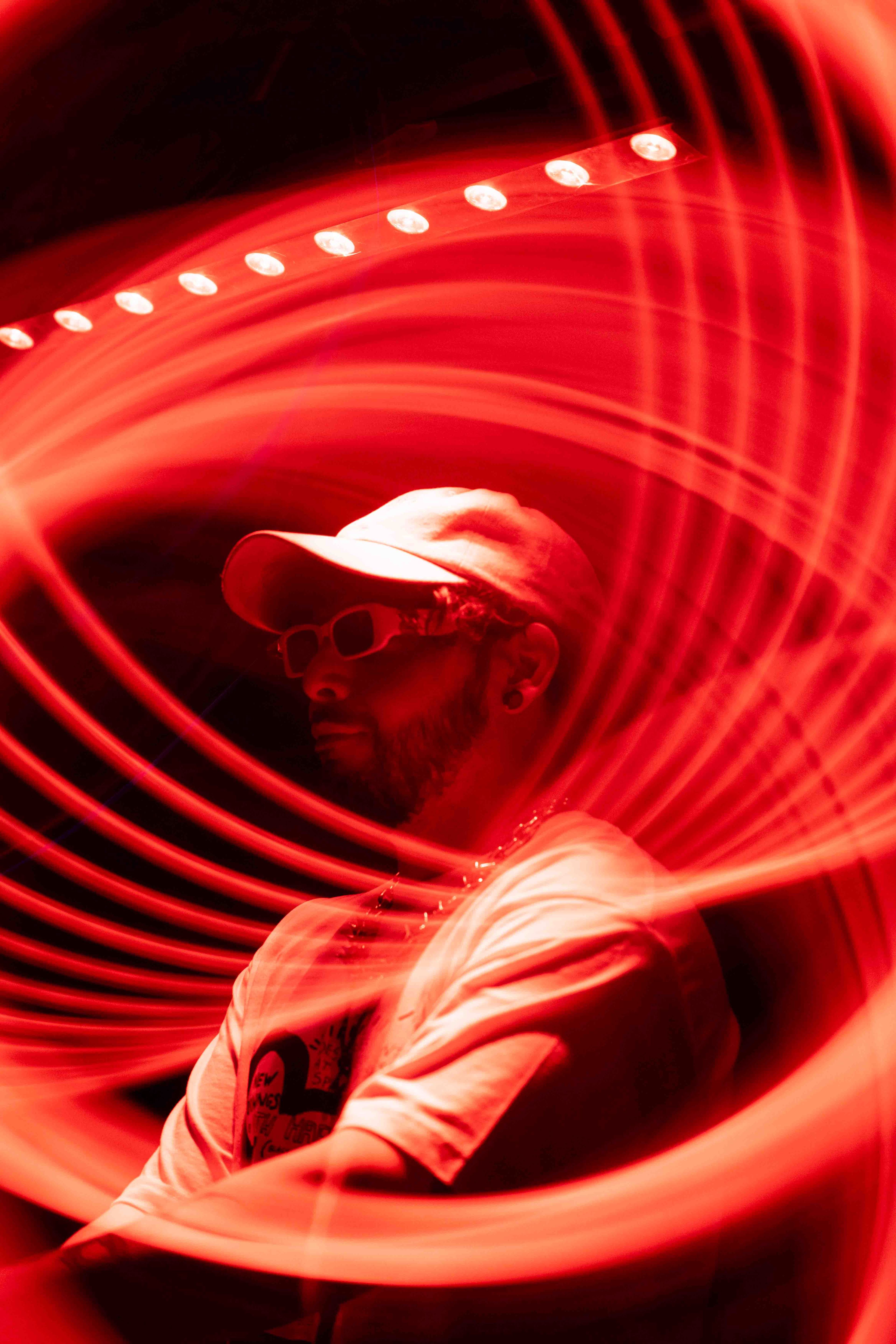 Lead vocalist gripping microphone stand with dramatic amber spotlight from above