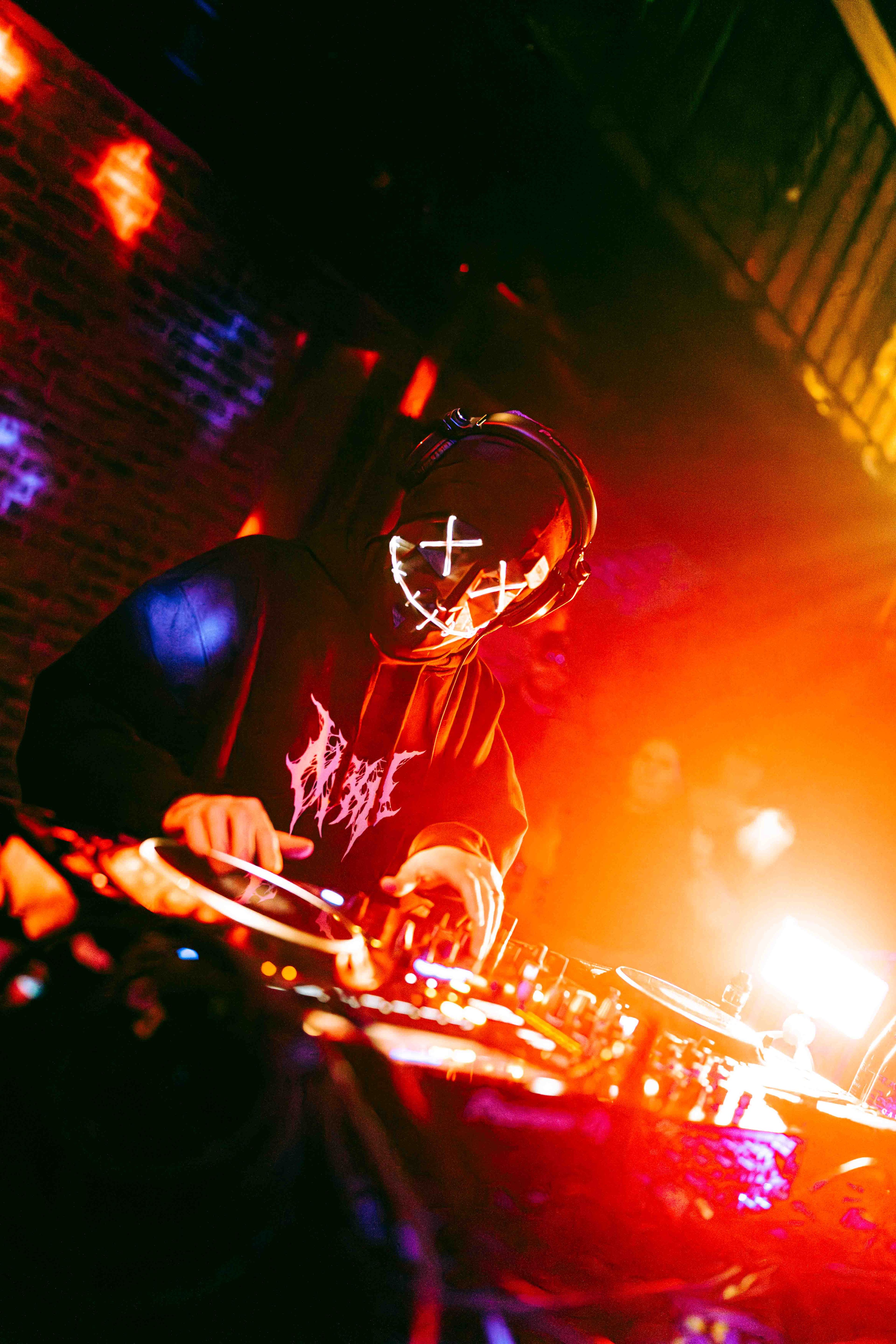 DJ performing at festival with massive LED screen backdrop and laser light show