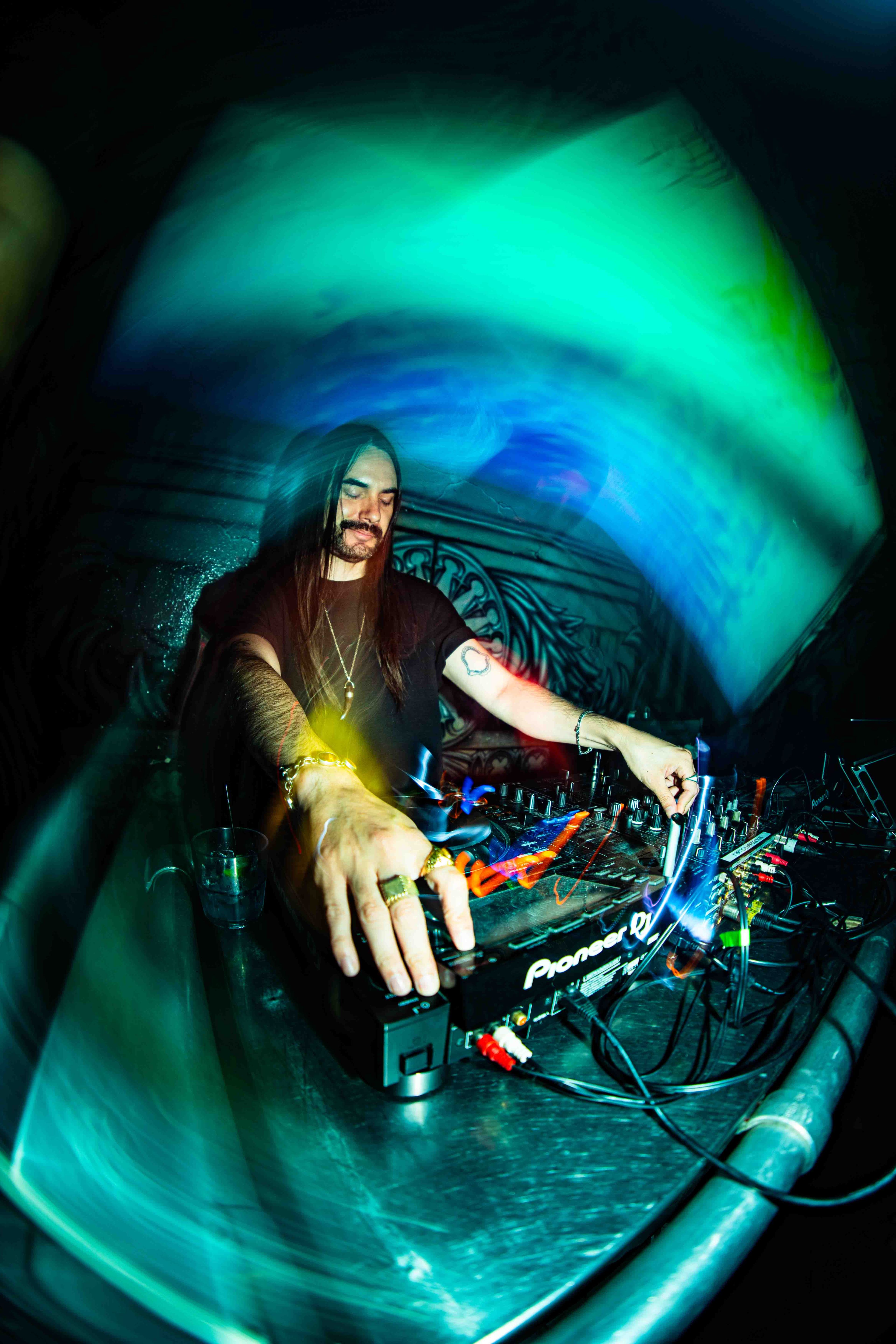 Band performing on outdoor stage at sunset with golden hour light mixing with stage lights